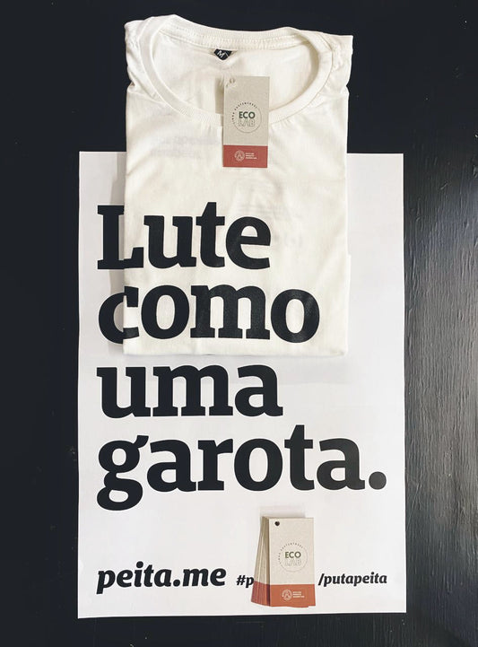 foto de uma camiseta bege e um cartaz branco. camiseta está sobreposta em e completamenta a frase lute como uma garota.
