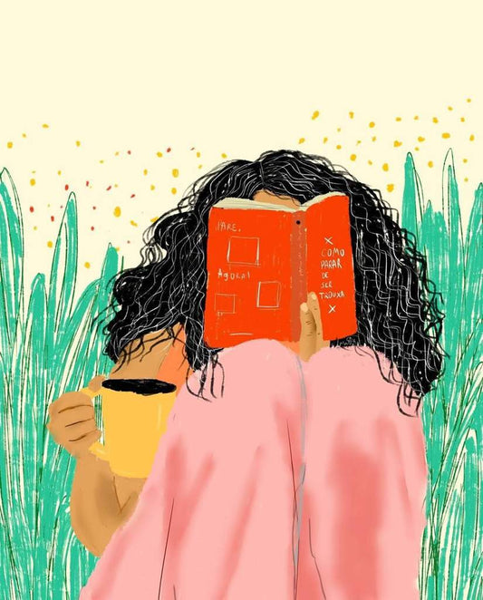 Ilustração colorida de uma garota negra, com cabelos compridos e cacheados, lendo um livro vermelho, segurando uma caneca amarela, com cobertor rosa nas pernas e simulação de folhas atrás. 